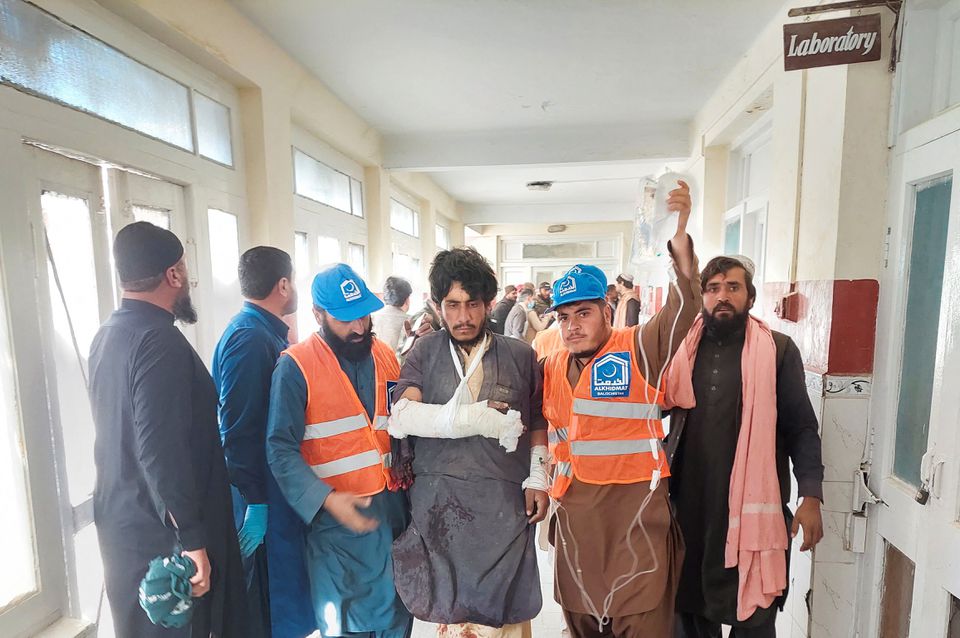 Rescue workers escort a man injured during cross-border shelling and gunfire, at a hospital in the Pakistan-Afghanistan border town of Chaman, Pakistan December 15, 2022. REUTERS/Abdul Khaliq Achakzai