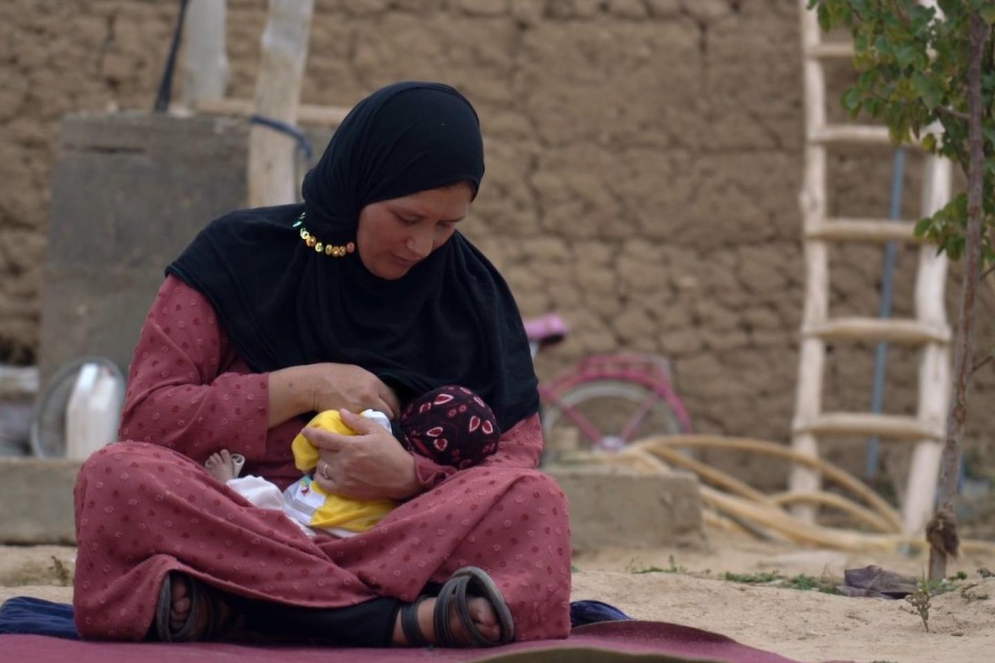 An Afghani woman breastfeeding her child
