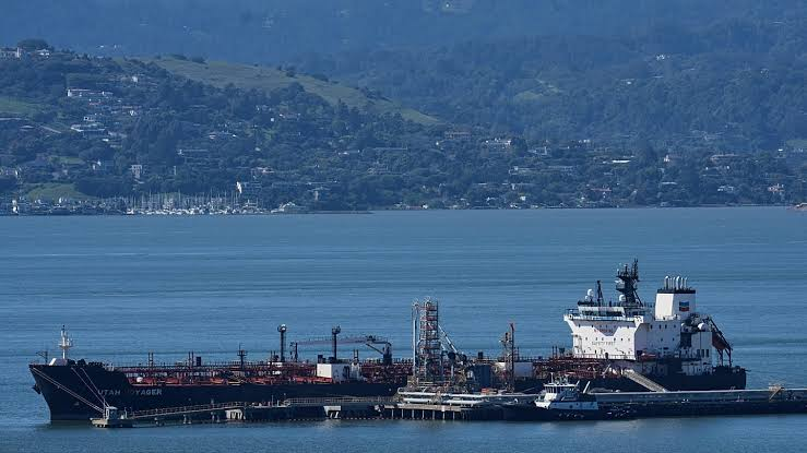 Oil tanker Utah Voyager docked at a marine terminal with coastal hills in the background