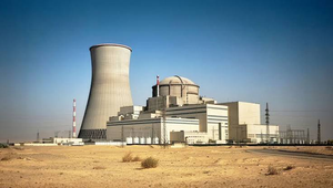 Nuclear power plant facility with a large cooling tower and containment dome in a desert landscape