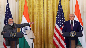 Narendra Modi gestures while speaking beside Donald Trump at podiums with US and Indian flags behind them