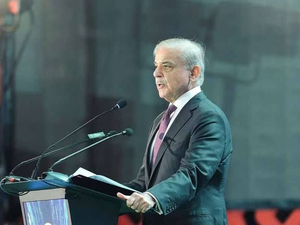 Pakistan's PM Shehbaz Sharif speaking at a podium with microphones