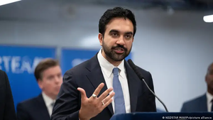 Zohran Mamdani gestures while speaking into a microphone at a press conference
